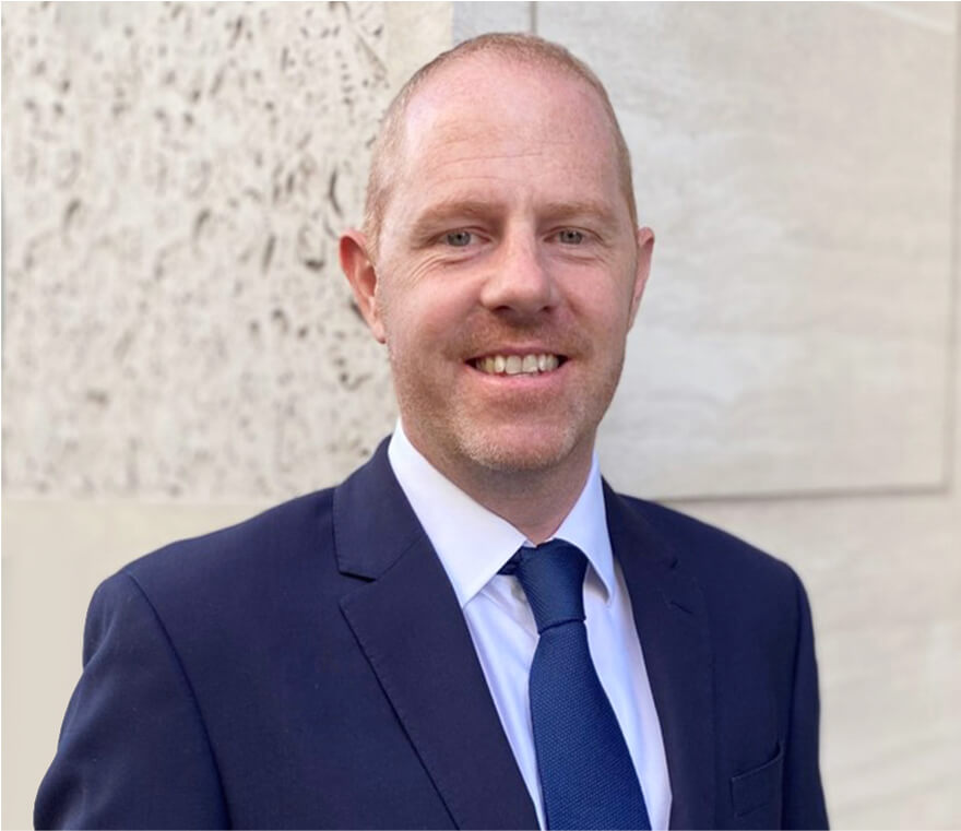 Man in suit smiling outdoors