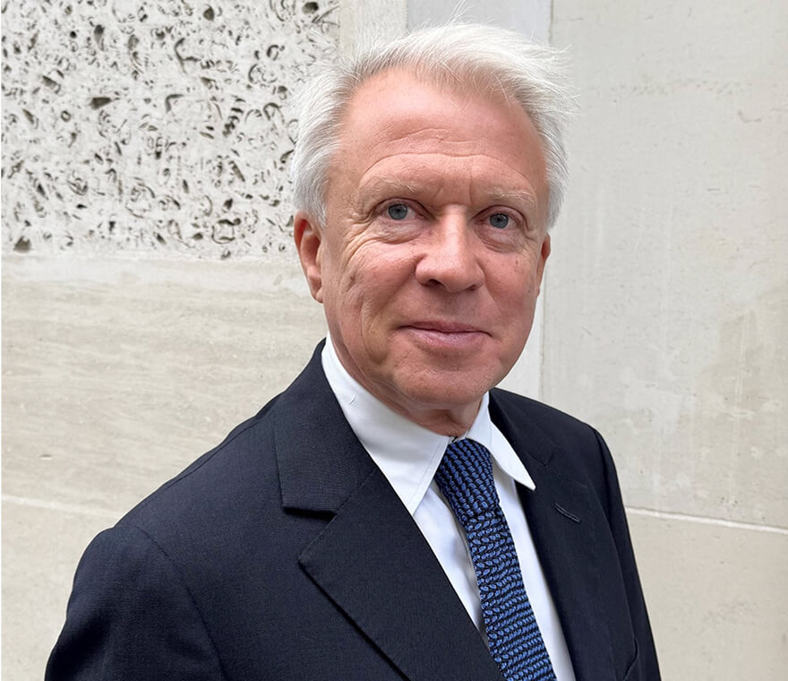 Elderly man in suit smiling outdoors