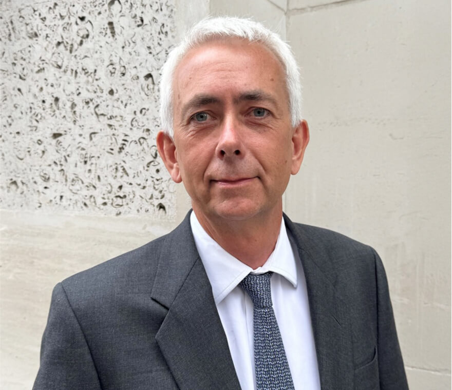 Man in suit standing near textured wall