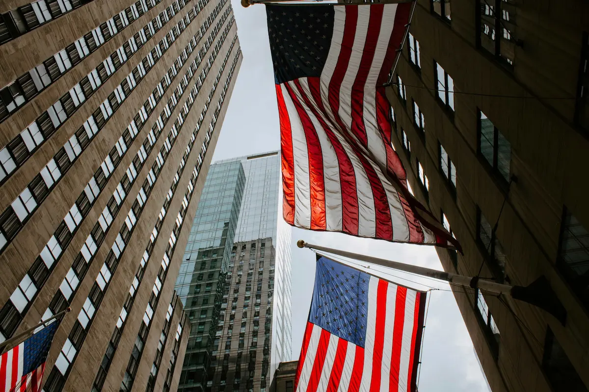 American flags between city skyscrapers.