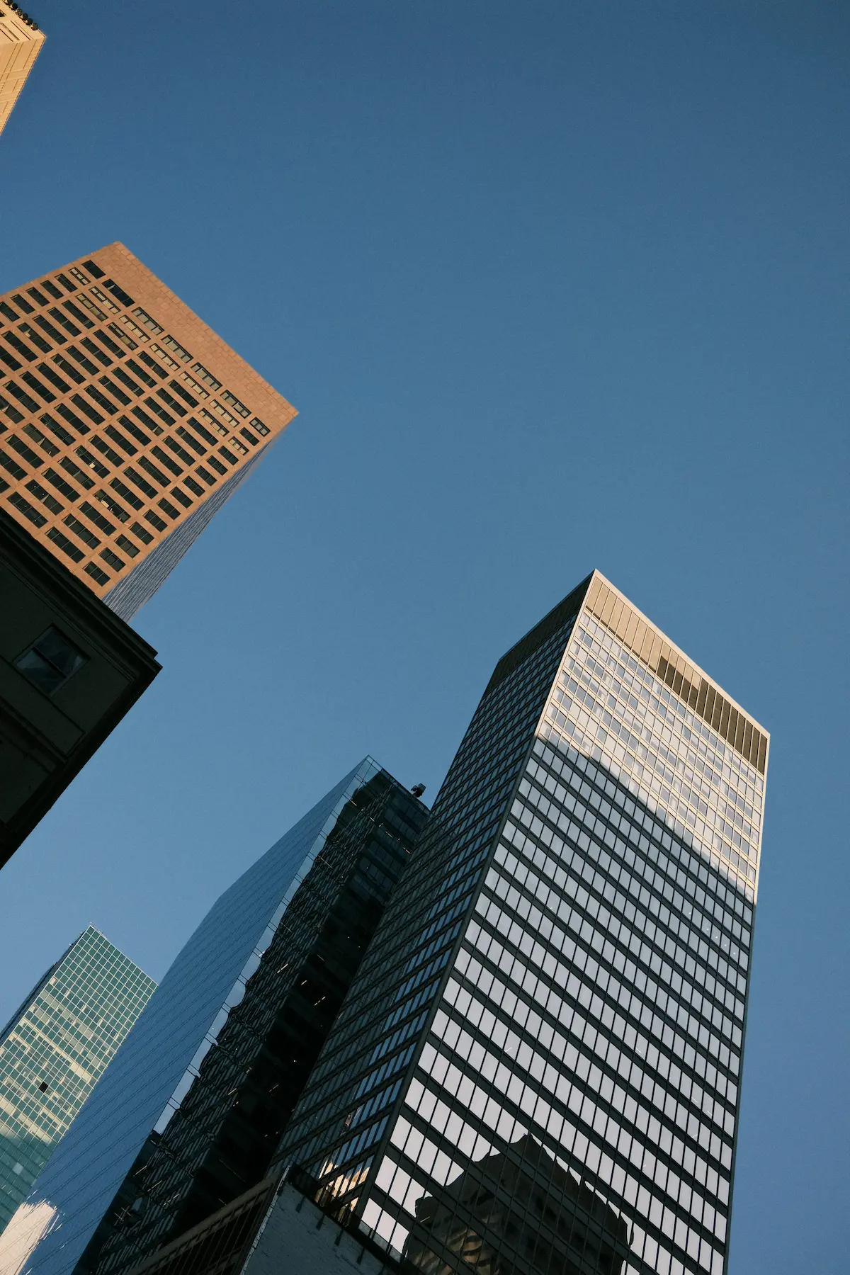 Low angle shot of skyscrapers against blue sky.