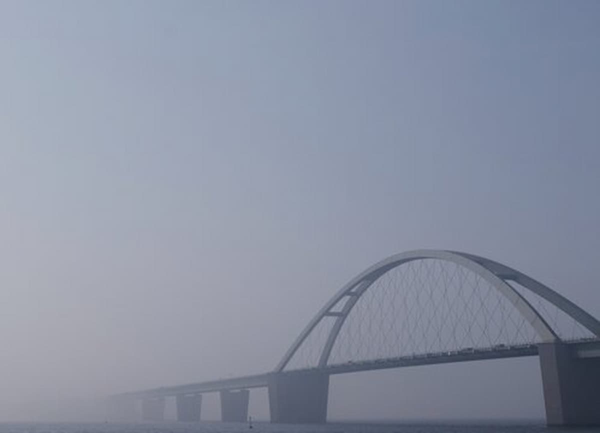 Bridge arching over misty water scene