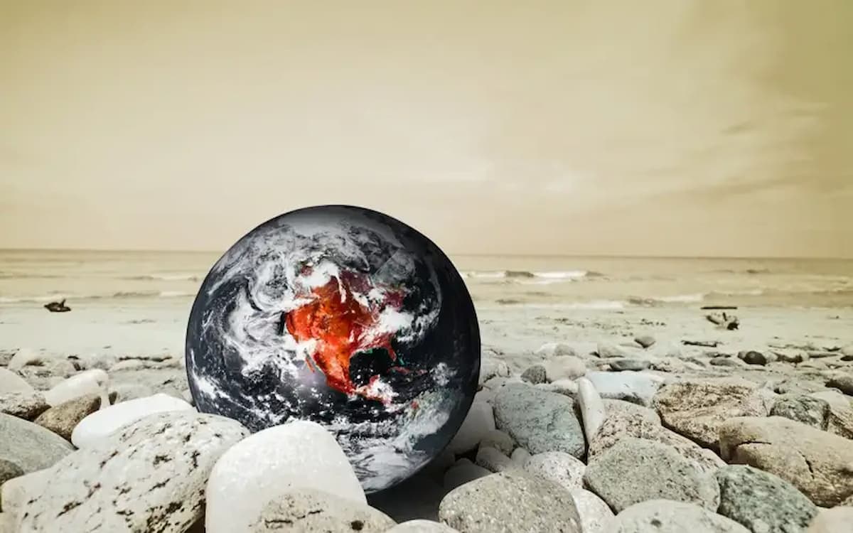 Globe resting on rocky beach.