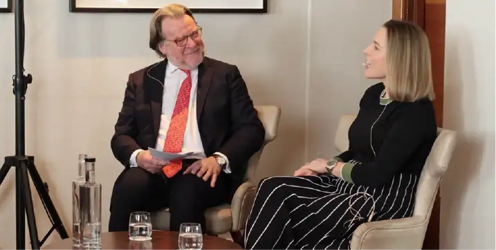 Two people having a professional conversation in chairs.