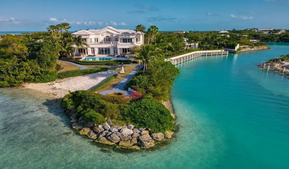Luxury waterfront mansion with turquoise water views.