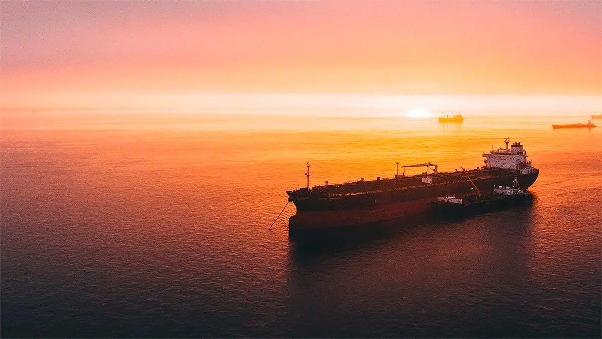 Cargo ship at sunset on the ocean.