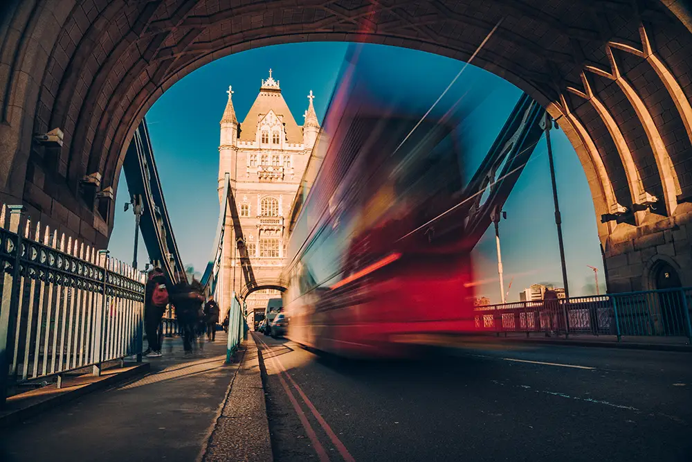 Red double-decker bus on Tower Bridge, London.